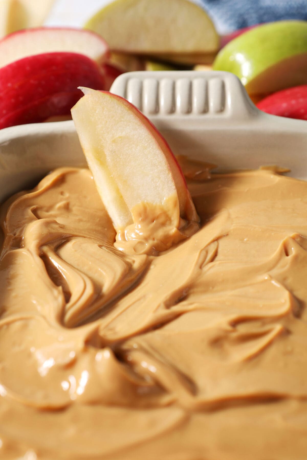 Close up of two apple slices sitting in dulce de leche dip