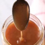 A spoon drizzles caramel sauce back into a mason jar