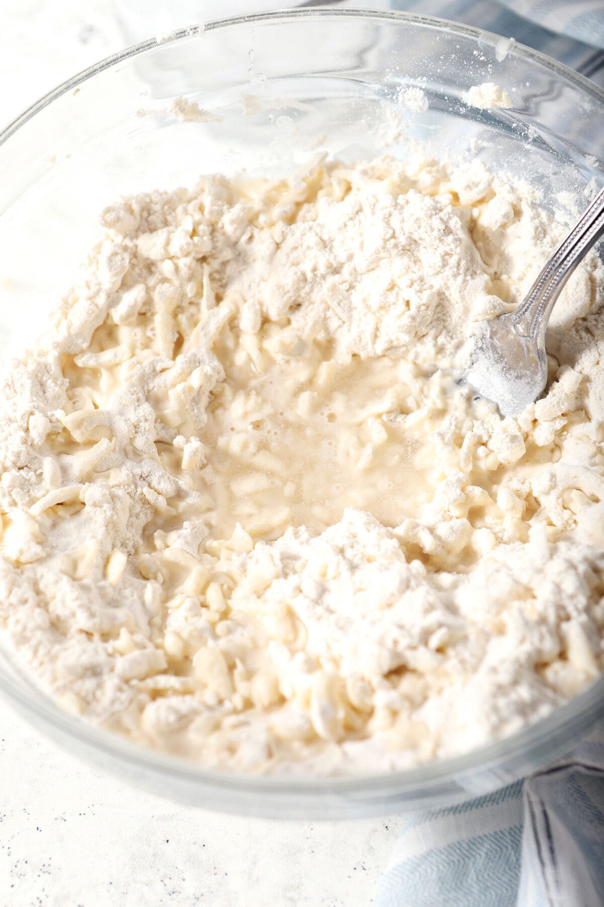 A bowl of pie crust as it begins coming together