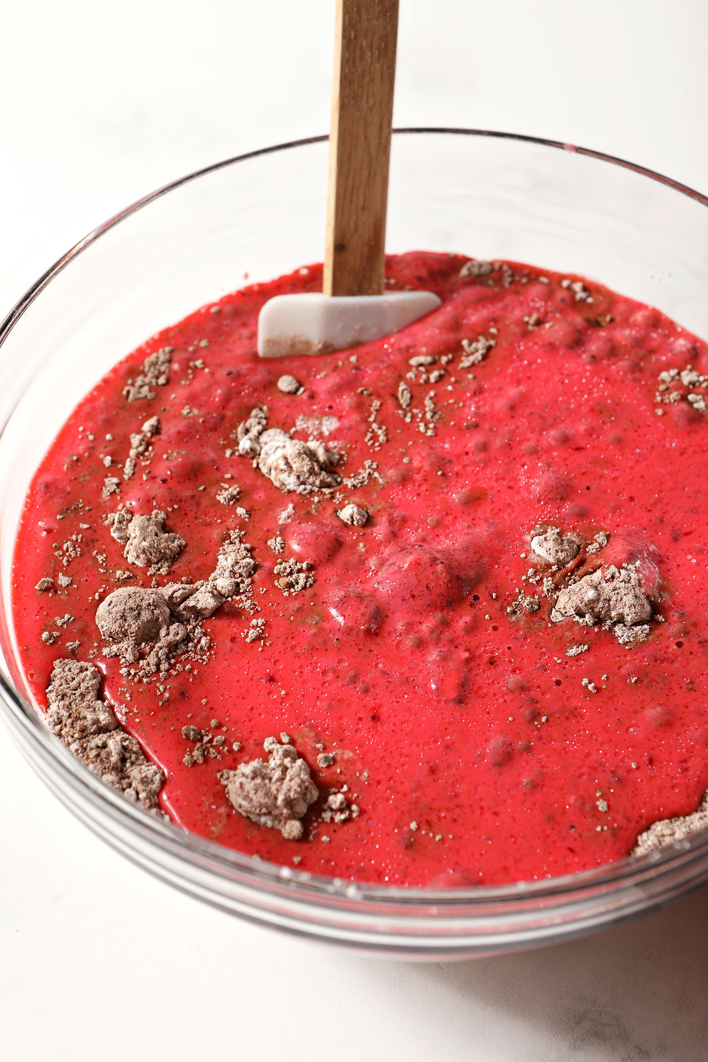Wet ingredients on top of dry ingredients in a bowl to make red velvet waffles