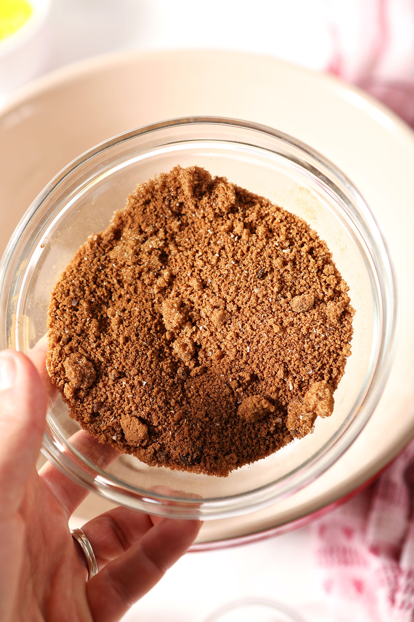 Dry ingredients for cinnamon roll filling in a bowl held in a hand