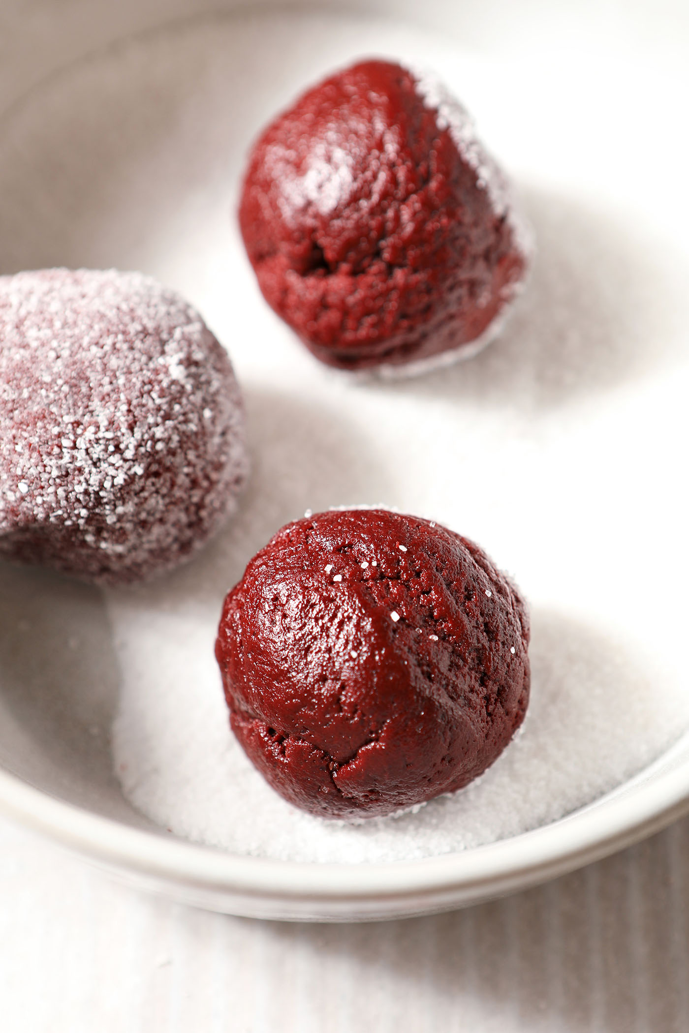 Cookie dough balls in a bowl of sugar