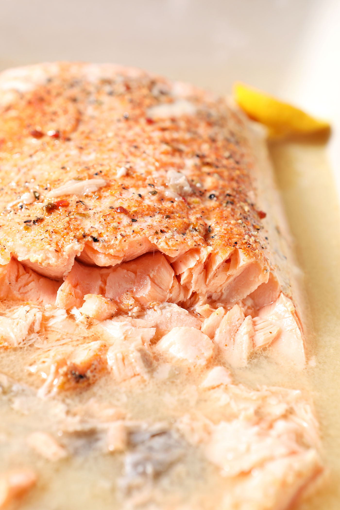 A large salmon slab cut into from the side in a white casserole dish