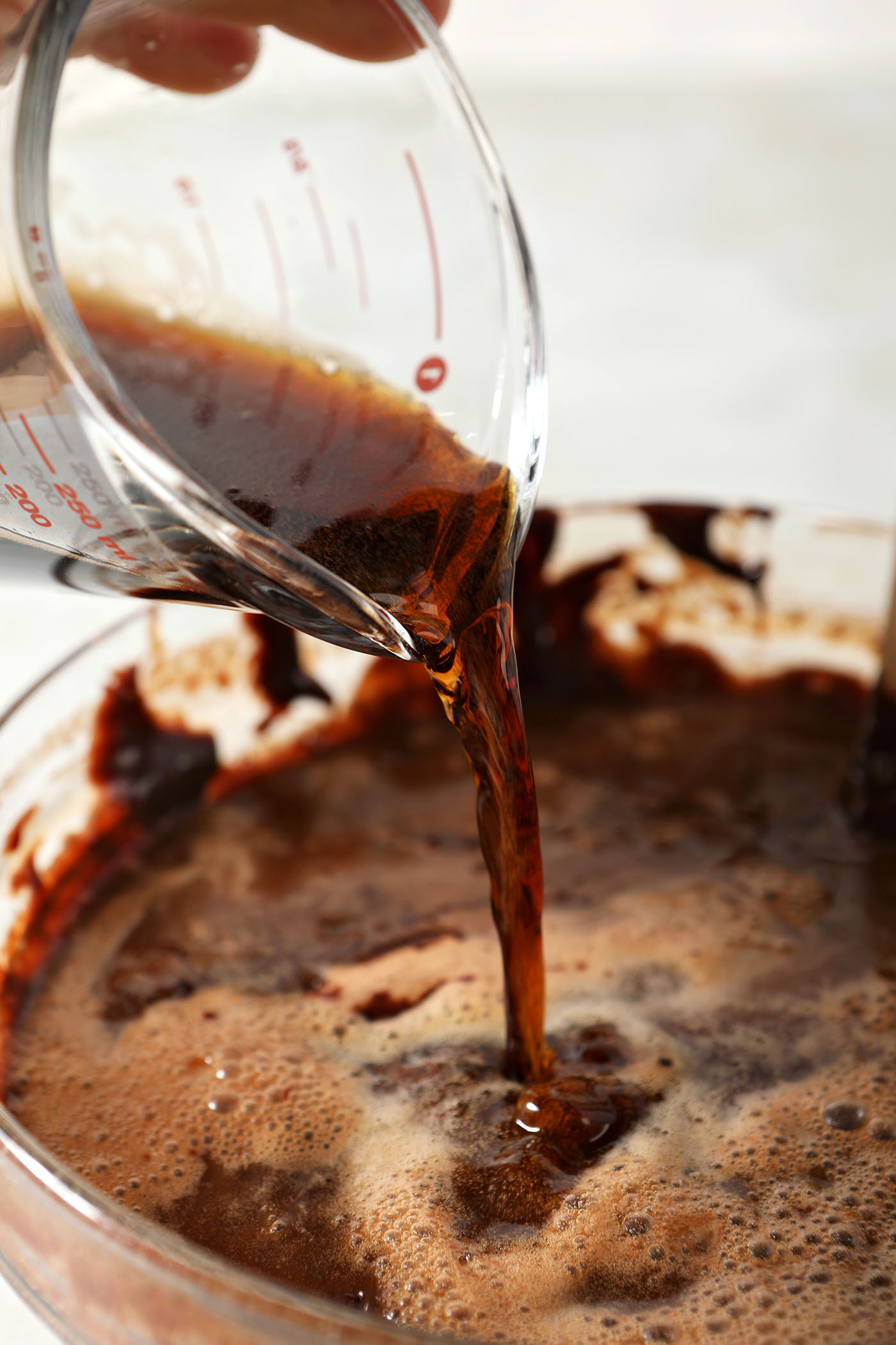 Beer pours into brownie batter in a bowl