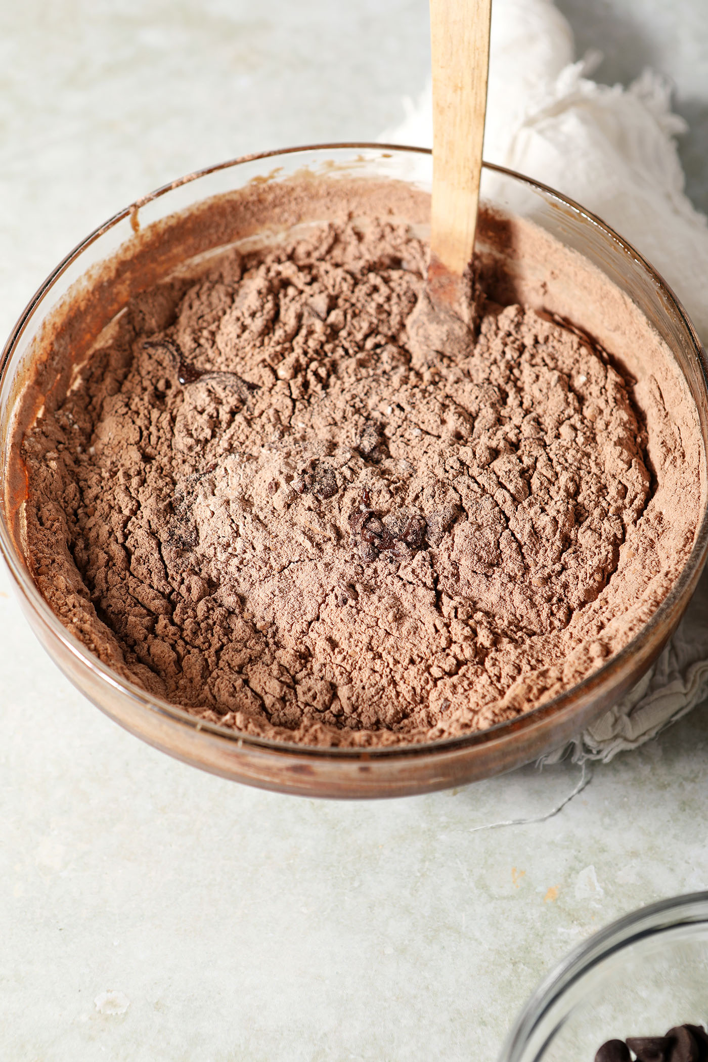 Dry ingredients in the bowl to make brownie batter before mixing on a green surface