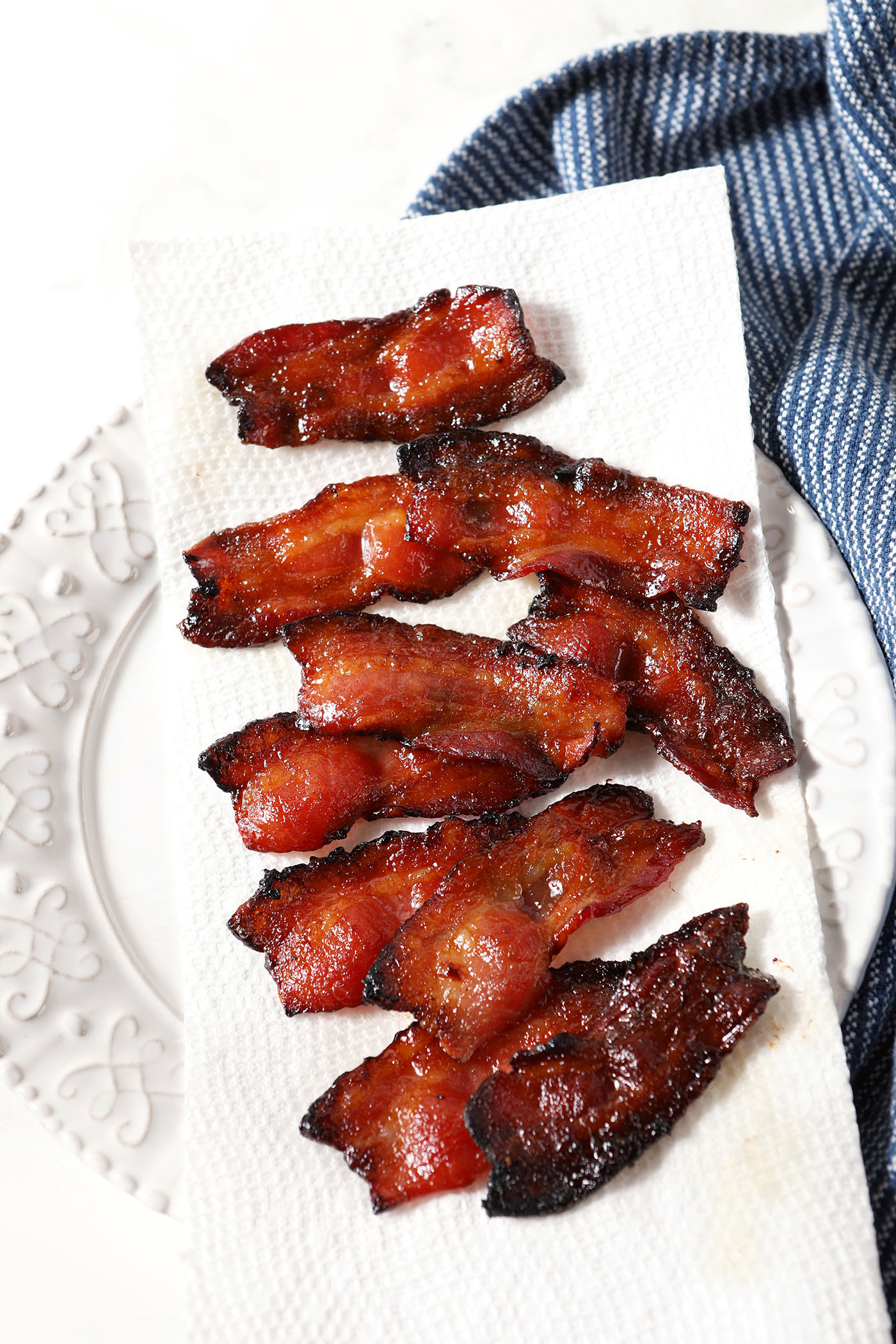 A paper towel-lined plate slices of fresh maple bacon