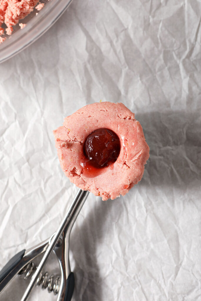 A filled Strawberry Lemonade Cookie in a scooper before finishing forming