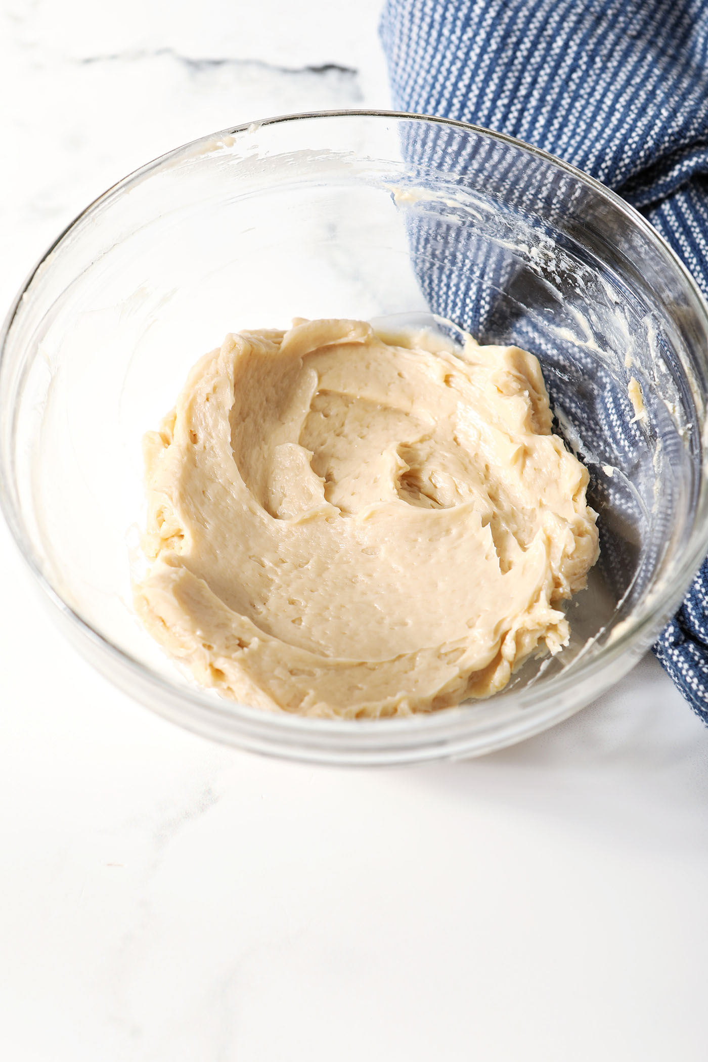 Maple butter in a bowl, after mixing, and next to a blue linen