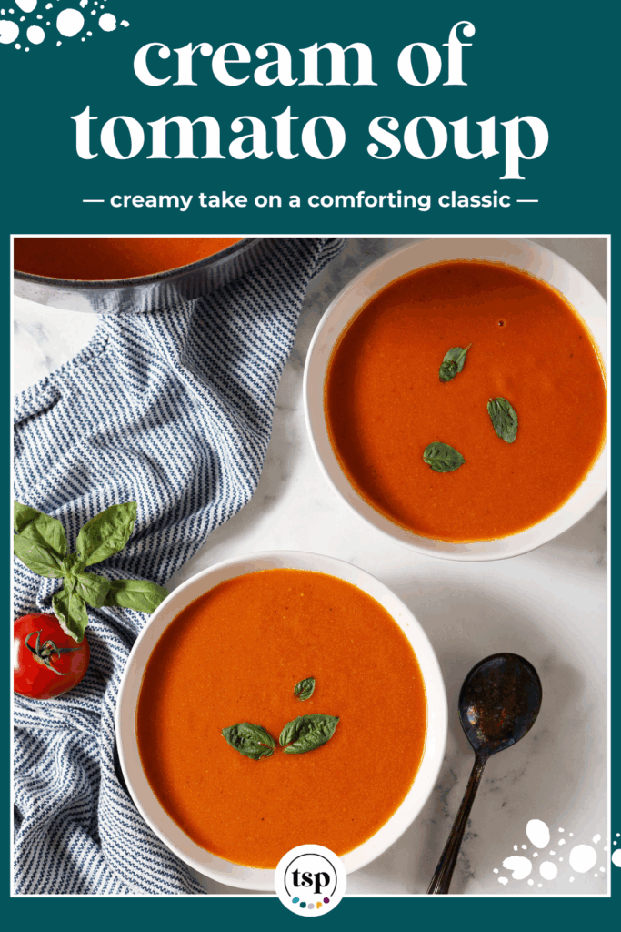 Two bowls of creamy tomato soup next to a dutch oven of soup with a blue and white linen and tomatoes and basil on a marble surface with the text cream of tomato soup creamy take on the comforting classic