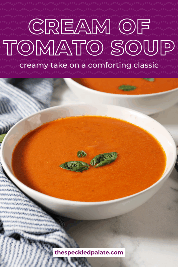 Side angle of two bowls of fresh cream of tomato soup next to a purple dutch oven, a blue and white striped linen and tomatoes and basil on a marble surface with the text cream of tomato soup creamy take on a comforting classic