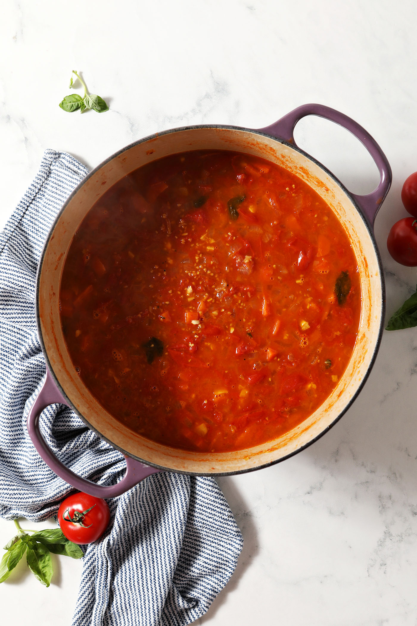 Tomatoes and other veggies in a dutch oven after cooking down to make soup