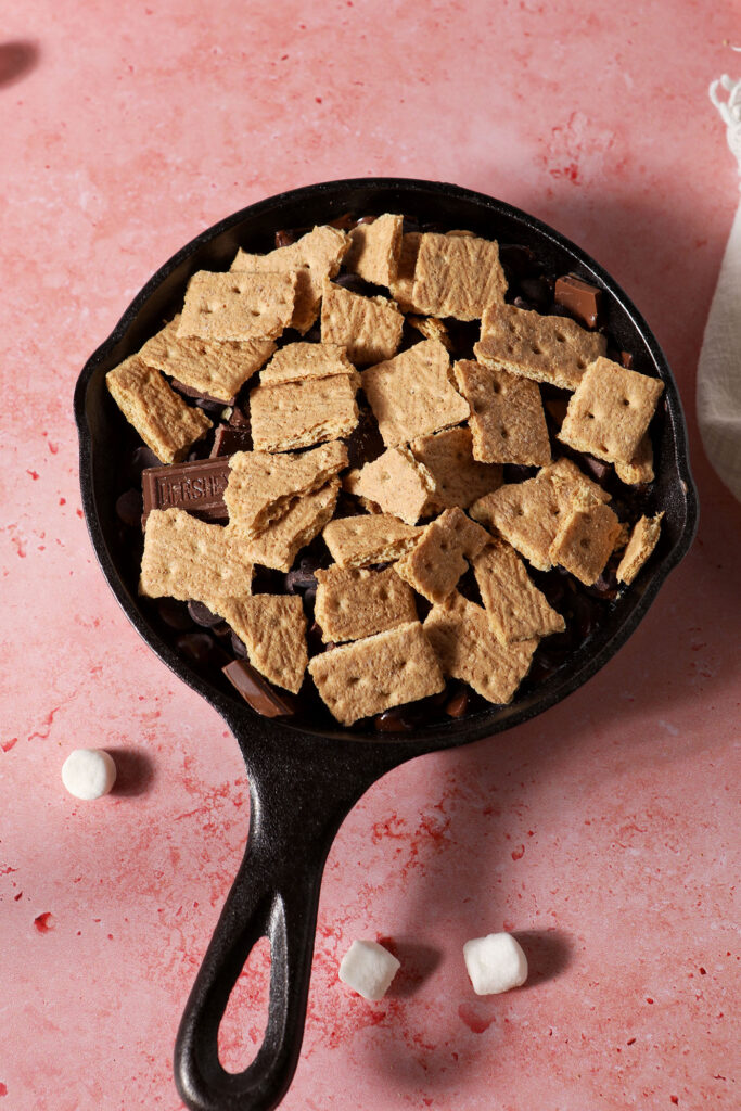 Graham crackers in a skillet on a pink surface