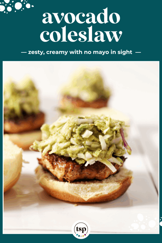 Avocado coleslaw on top of a bbq chicken burger on a white platter with the text avocado coleslaw zesty, creamy with no mayo in sight