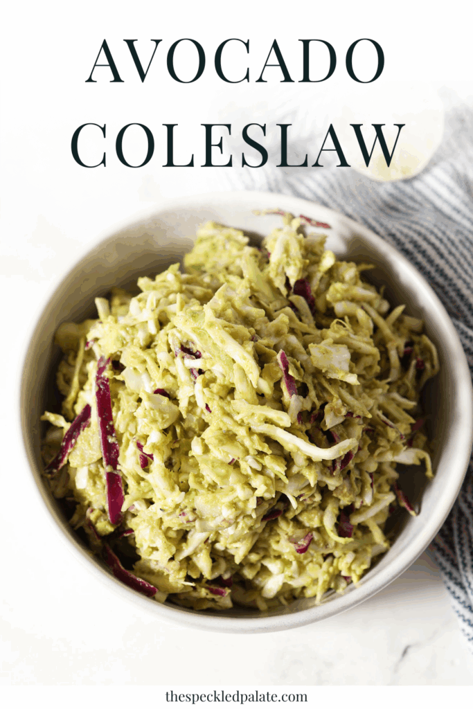 A green slaw in a bowl after mixing with the text avocado coleslaw