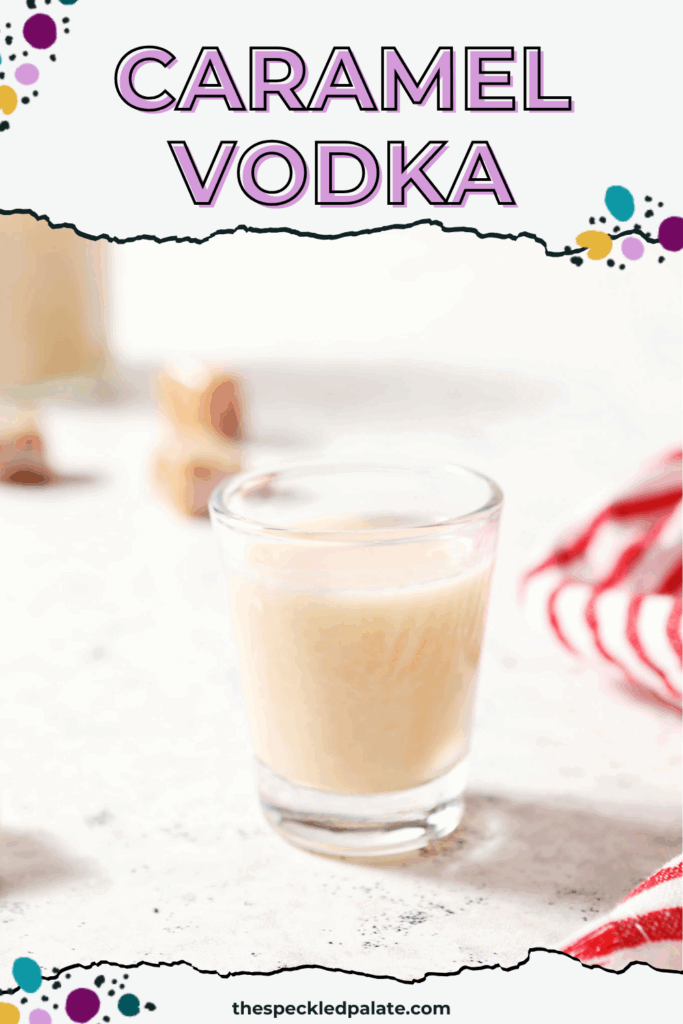 A shot glass holds a shot of caramel vodka on a textured white surface next to a white and red striped linen surrounded by soft caramels with the text caramel vodka