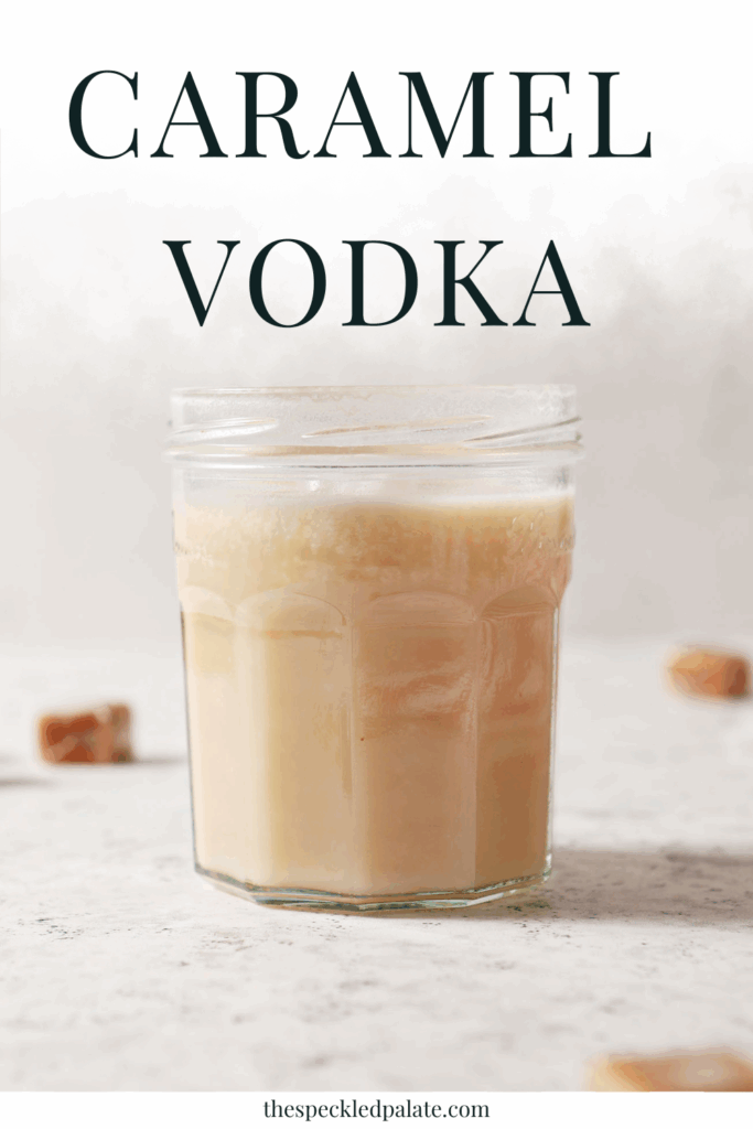 infused caramel vodka in a jar on a white stone surface surrounded by candy caramels with the text caramel vodka