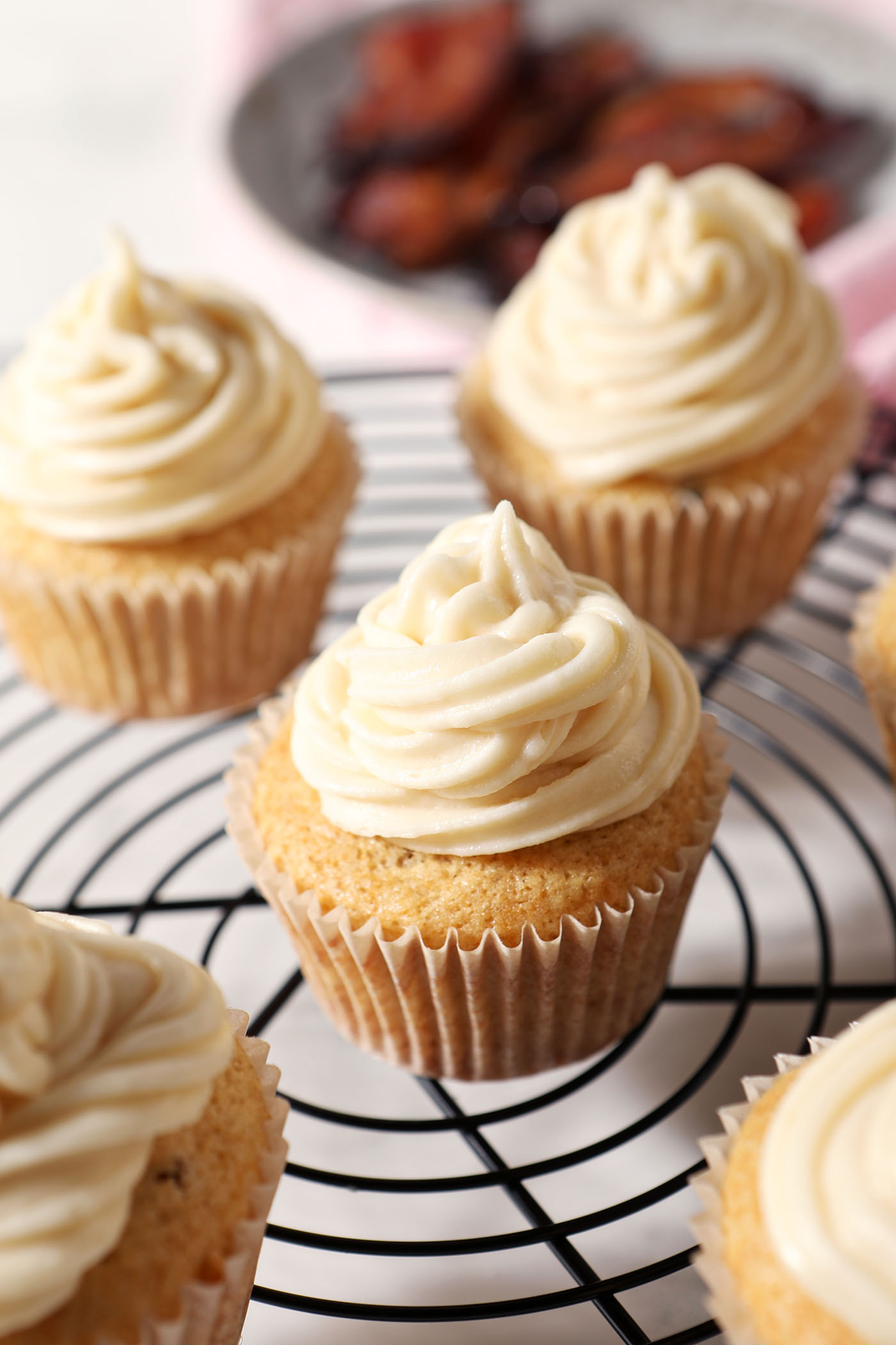 Overhead photo of cupcakes topped with salted maple frosting on a wire rack