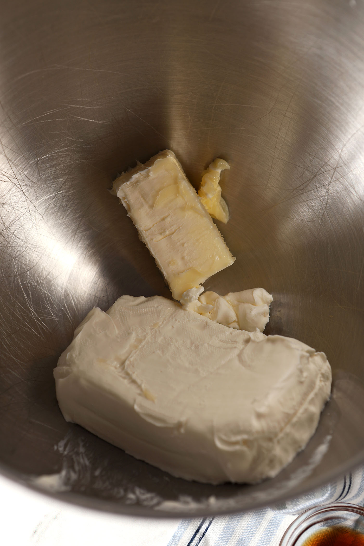 Softened cream cheese and butter in a metal bowl before creaming