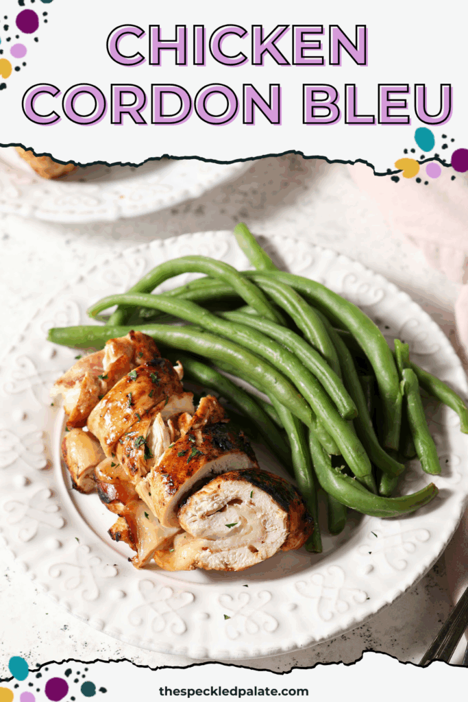 A plate of sliced baked chicken cordon bleu next to green beans on a stone surface with the text chicken cordon bleu