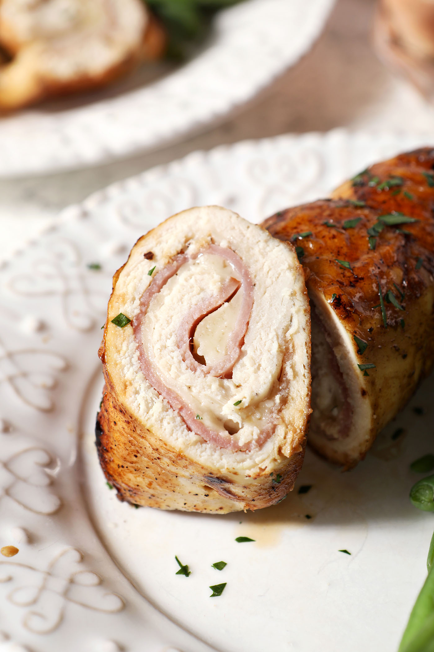 A sliced piece of chicken cordon bleu on a white plate