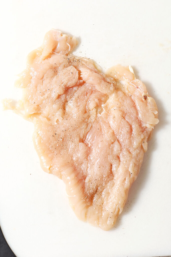 Close up of tenderized chicken breast before filling
