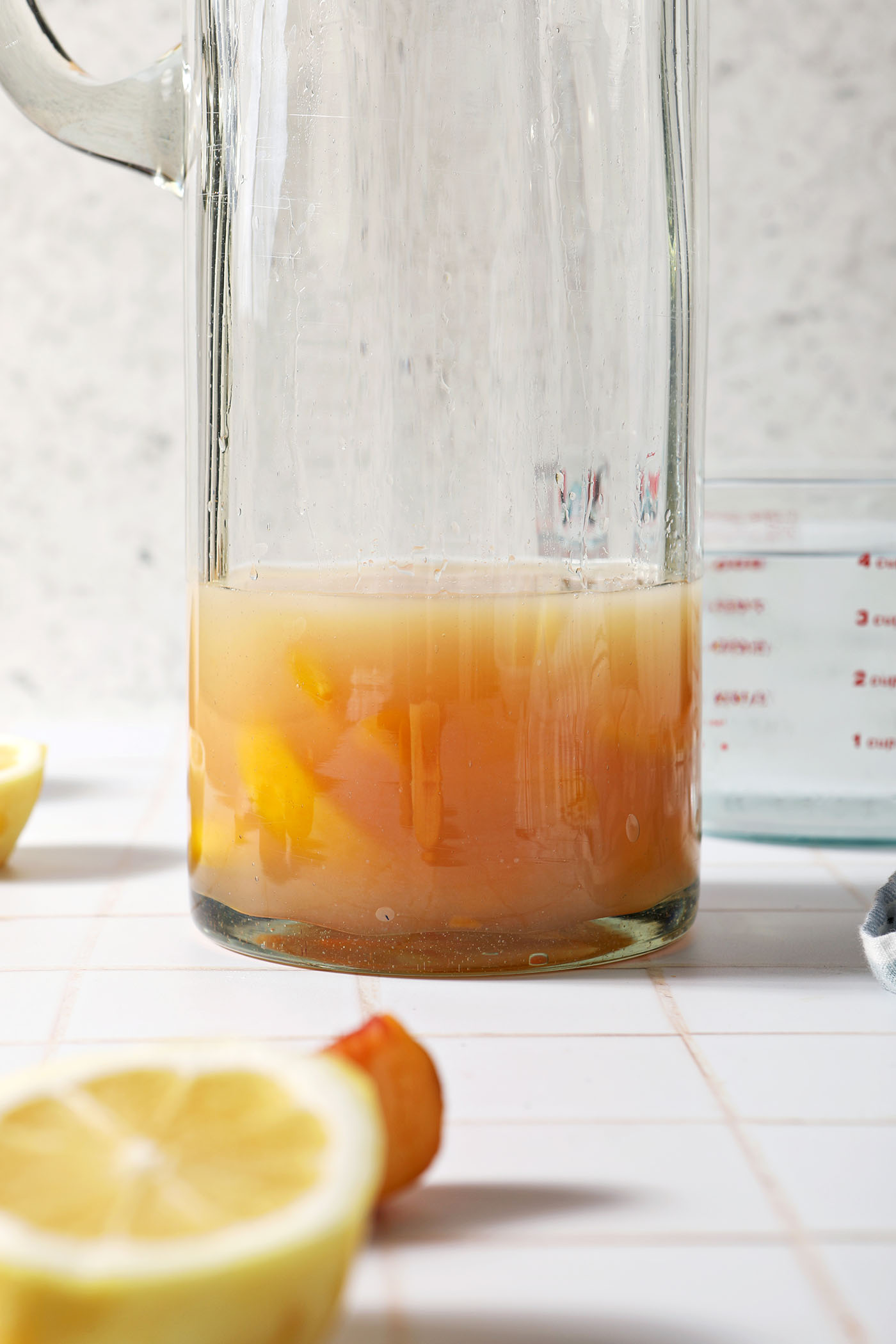 Liquid ingredients in a pitcher on a white tiled surface