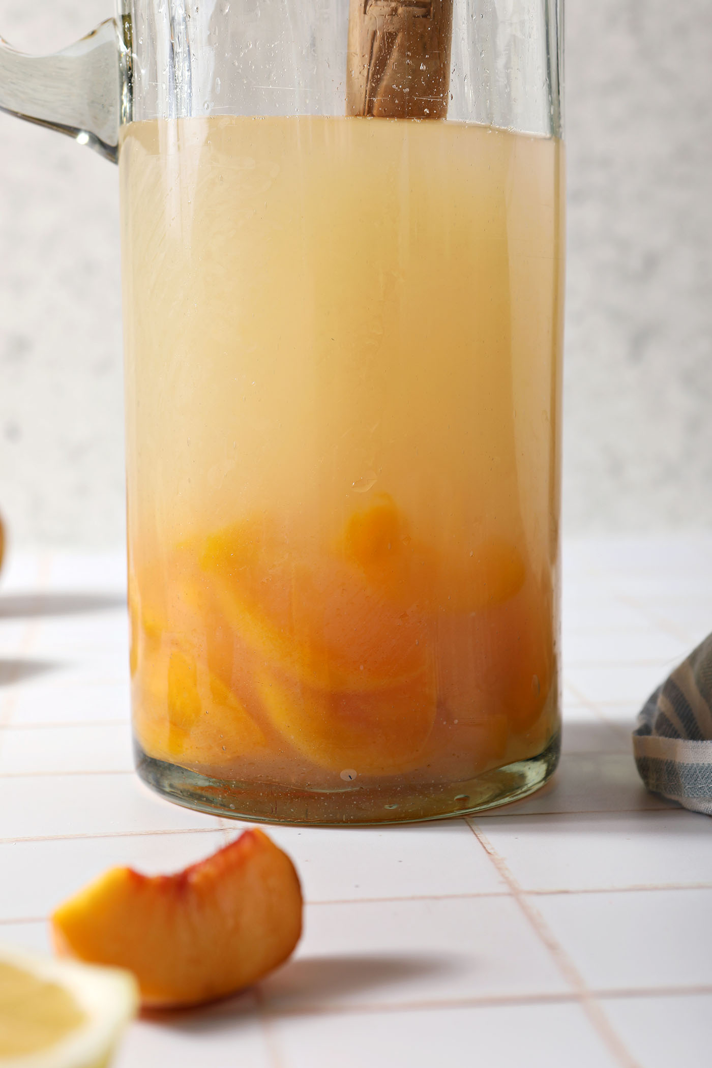 Liquid ingredients in a pitcher on a white tiled surface