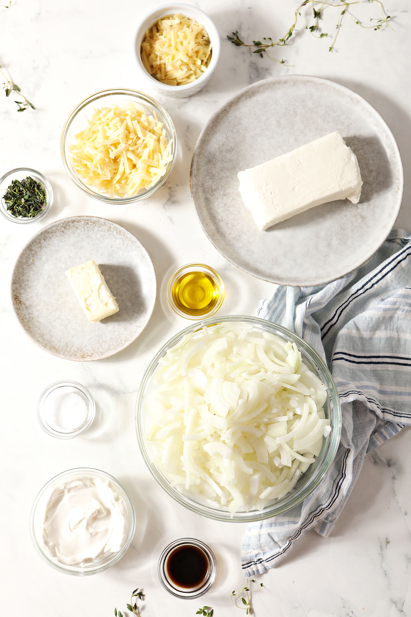 ingredients to make homemade onion dip in bowls on a marble surface