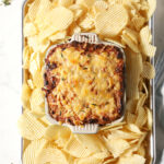 Overhead of Hot Caramelized Onion Dip after coming out of the oven surrounded by ruffled potato chips