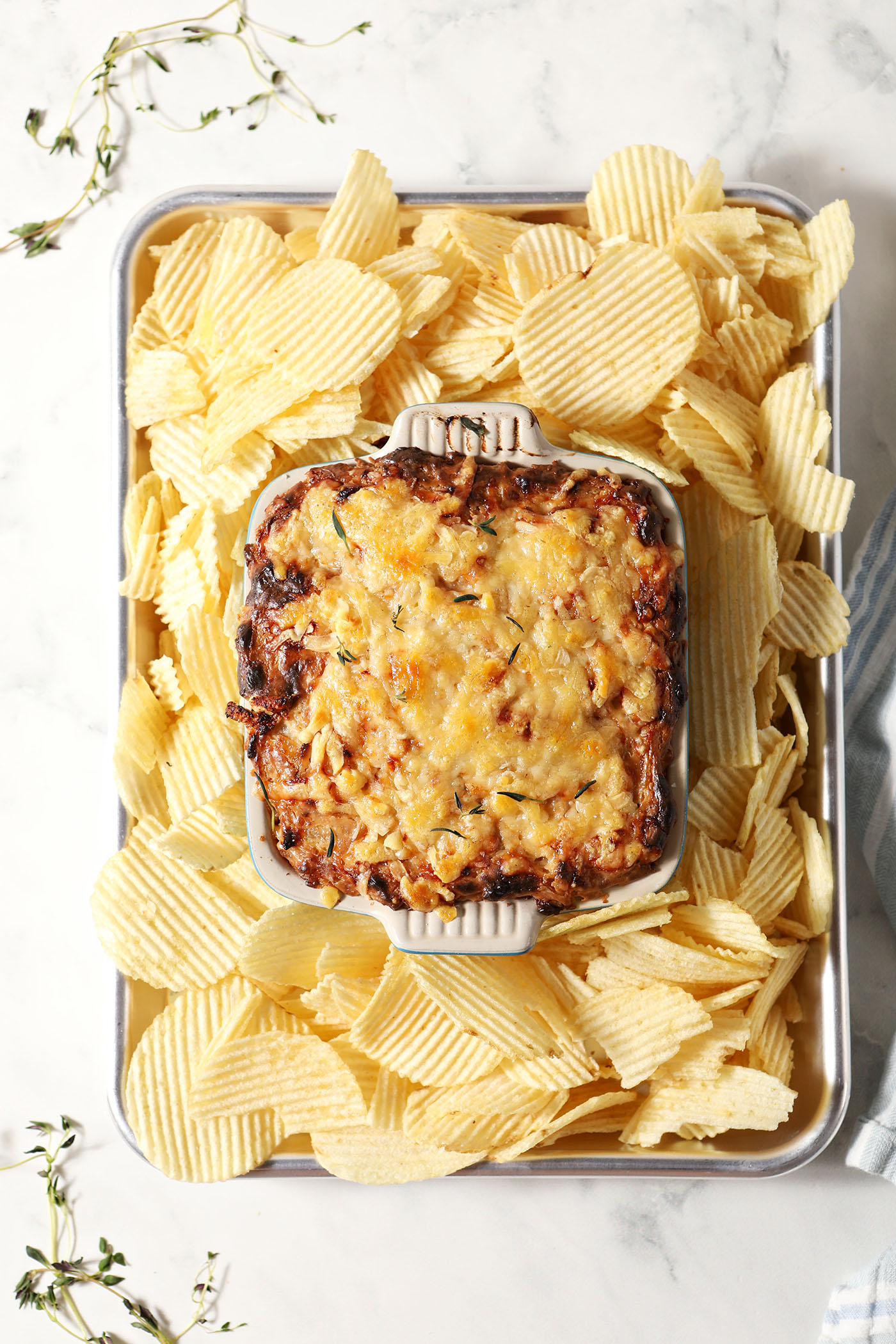 Overhead of Hot Caramelized Onion Dip after coming out of the oven surrounded by ruffled potato chips