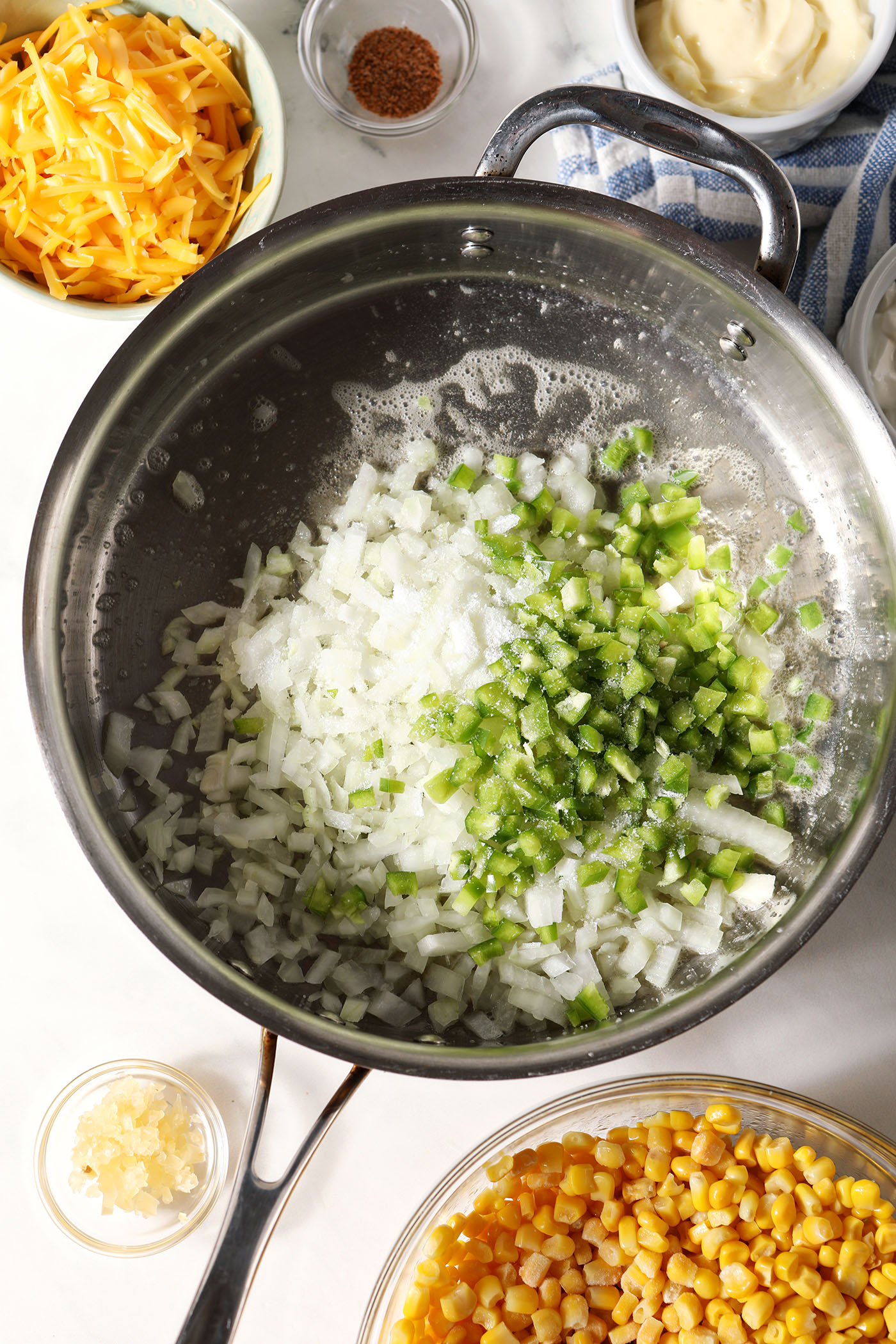Diced onions an green bell pepper in a saute pan before cooking