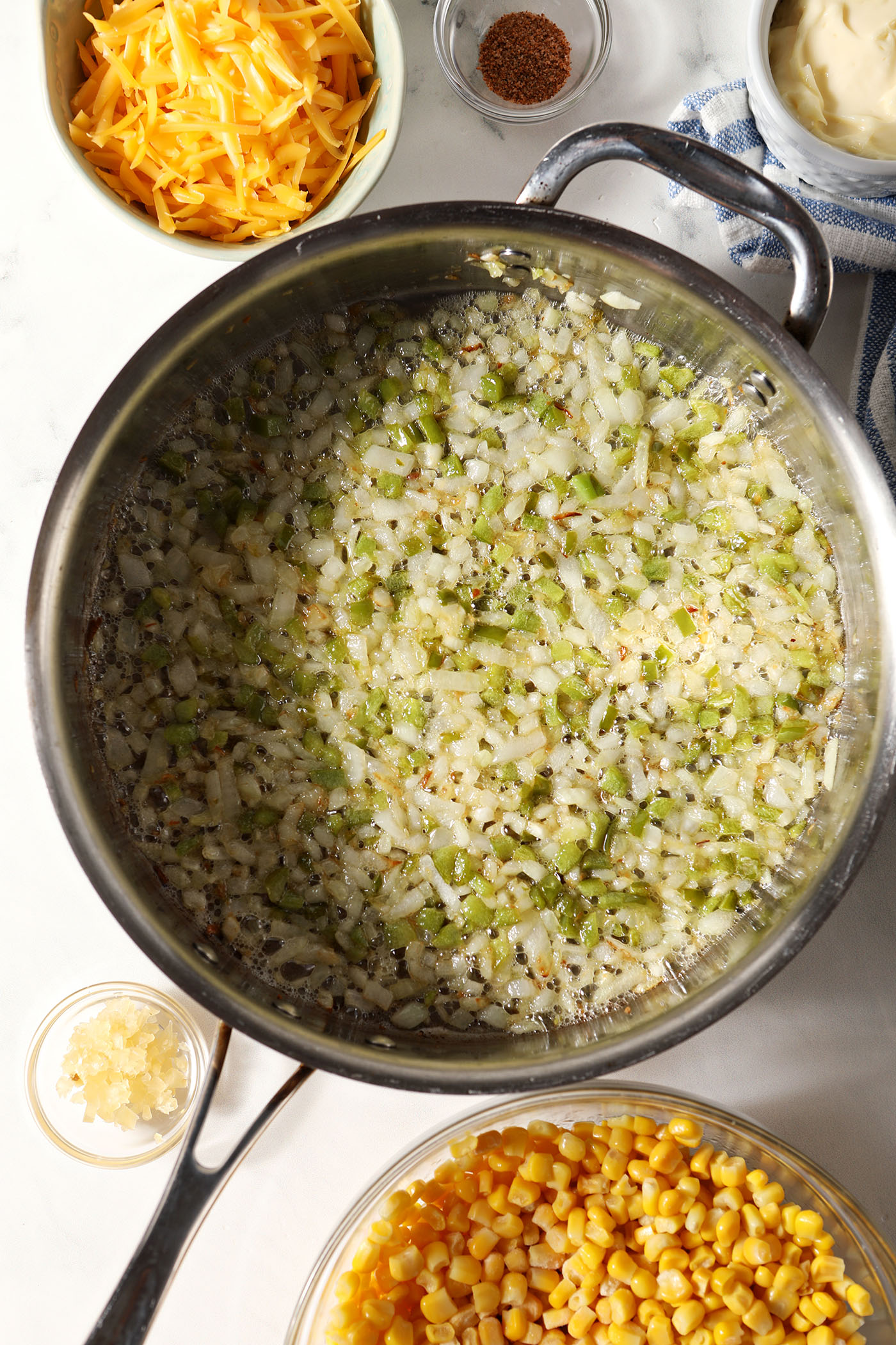 Diced onions an green bell pepper in a saute pan after cooking