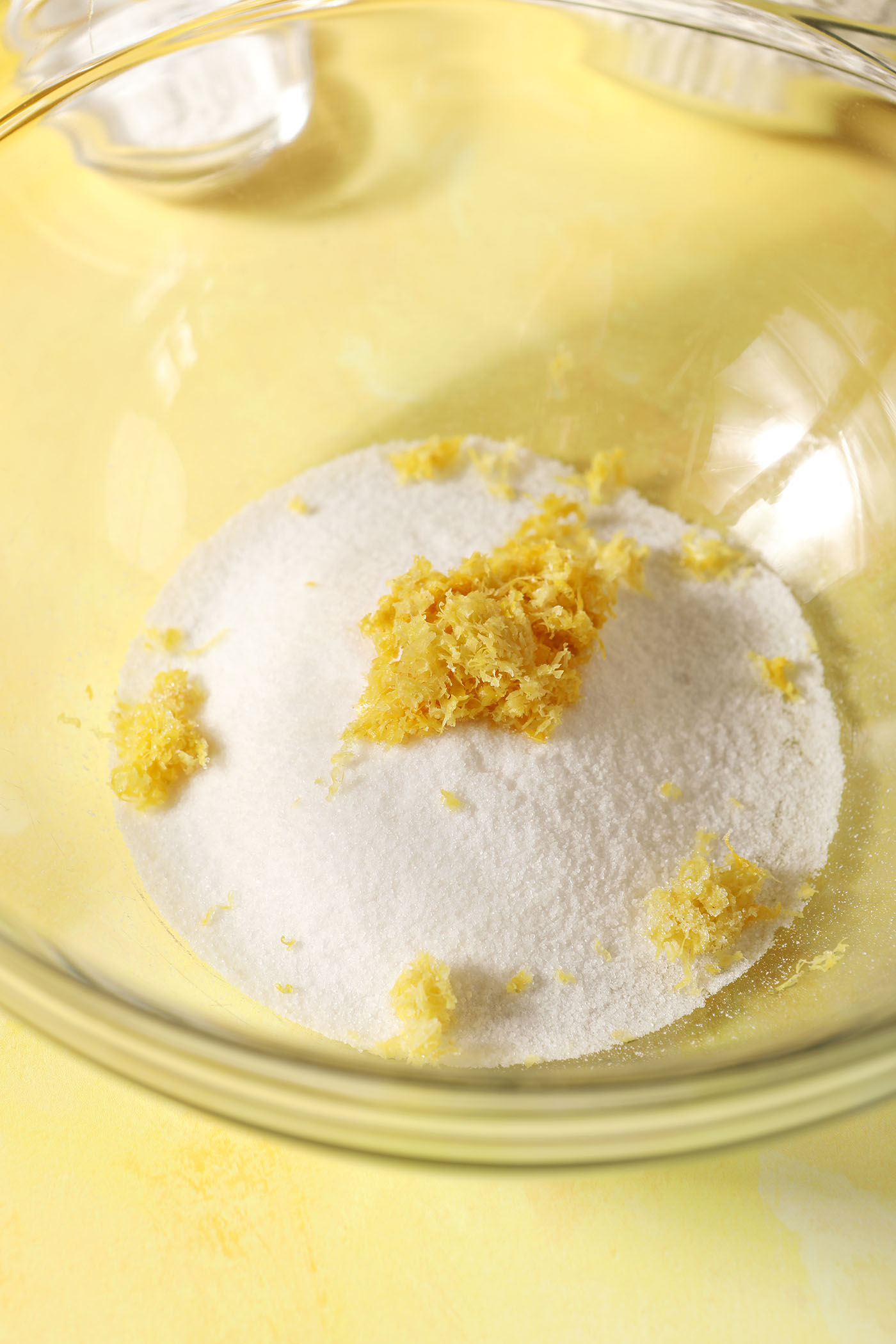 Lemon zest on top of granulated sugar in a large bowl
