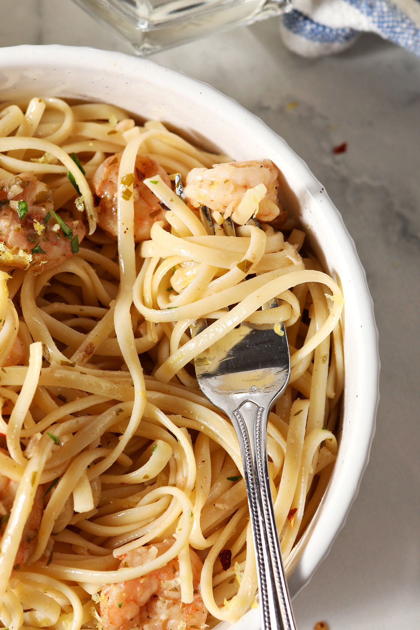 Pasta is swirled around a fork in a bowl of shrimp lemon pasta