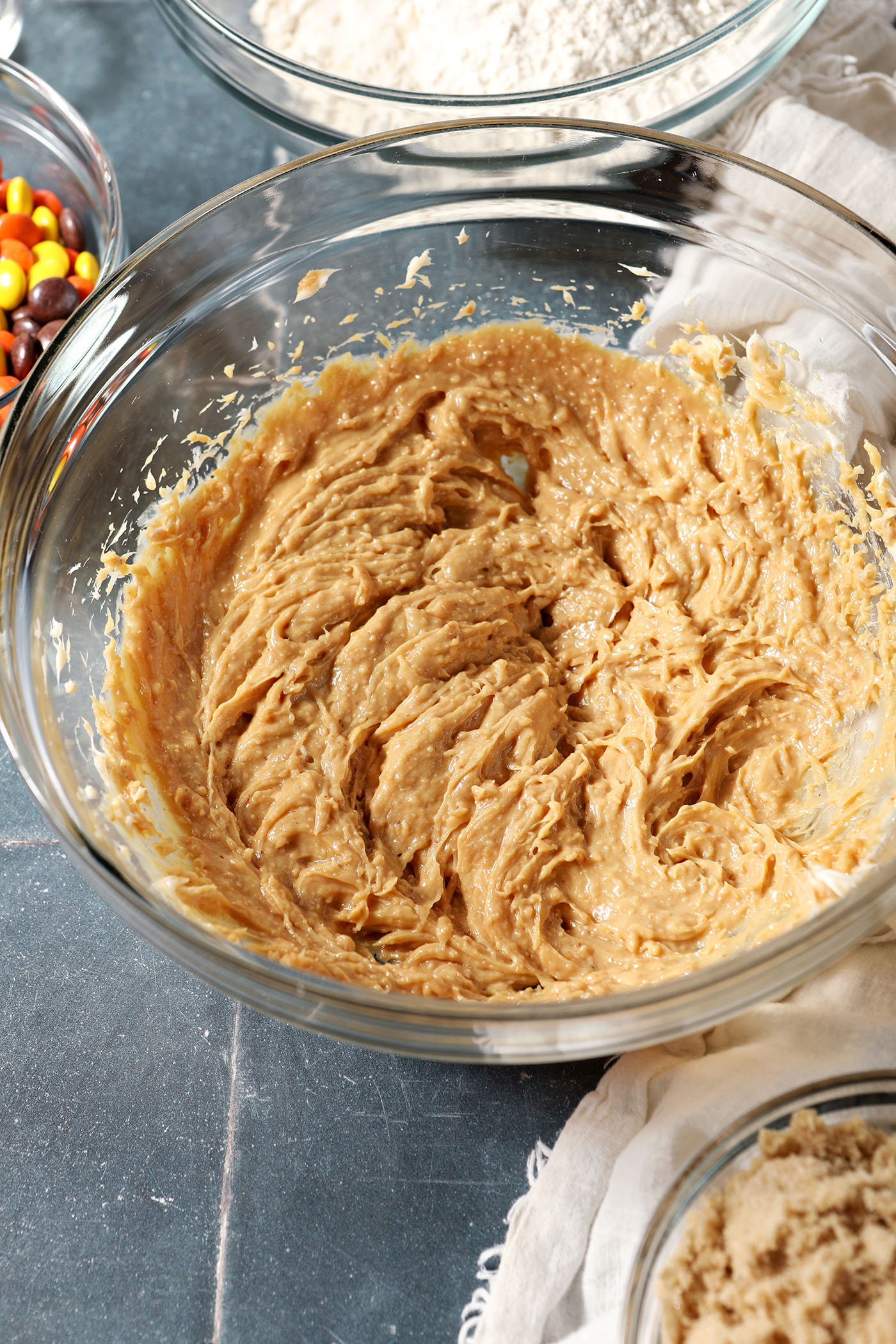 Blended peanut butter and butter in a bowl on a dark blue tiled surface