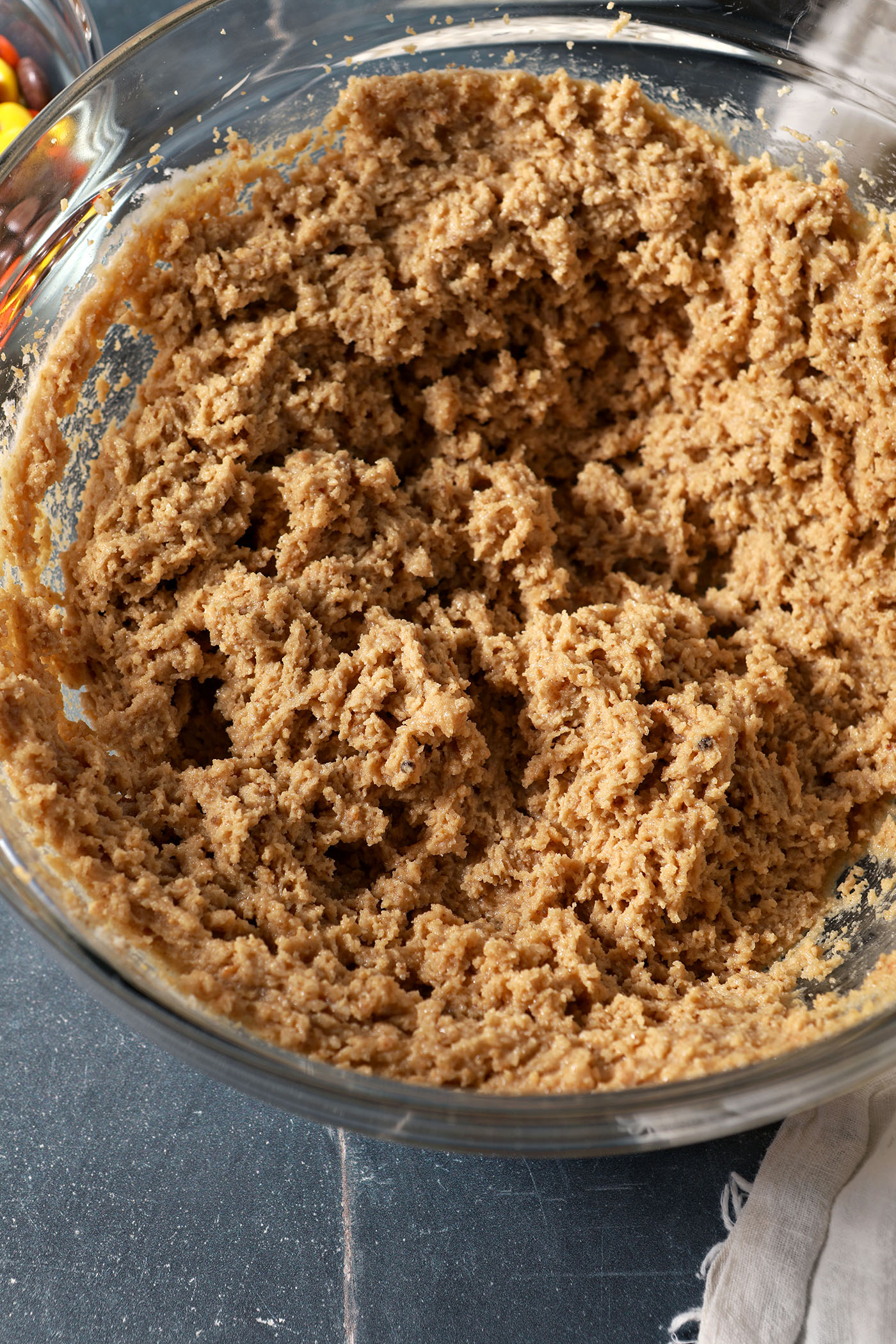 Creamed sugars, peanut butter and butter in a bowl on a blue tiled surface