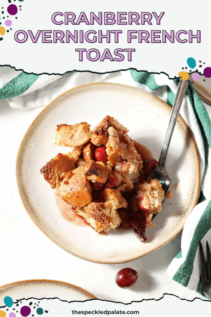 Overhead image of a plate of cranberry French toast casserole with a fork next to a green and white striped linen with the text cranberry overnight french toast