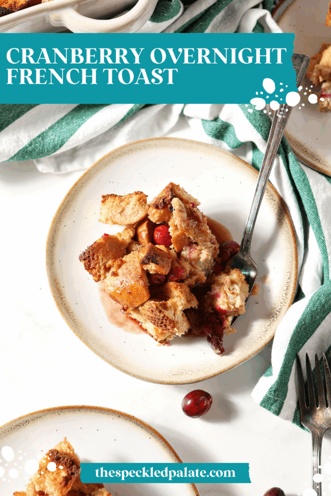 Overhead image of a plate of cranberry French toast casserole with a fork next to a green and white striped linen with the text cranberry overnight french toast