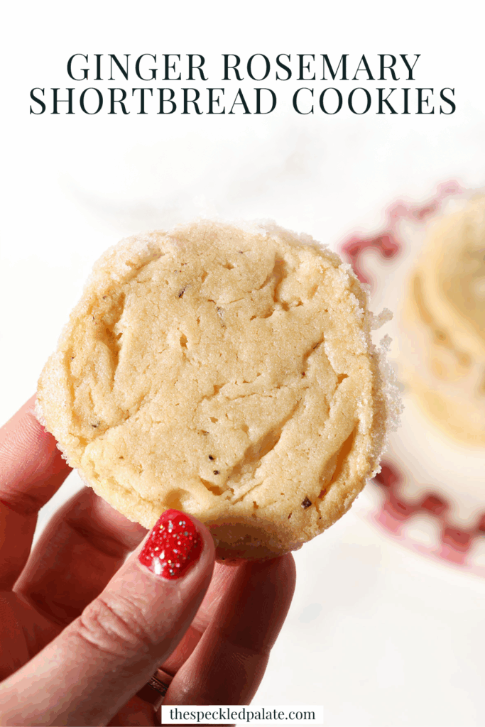 A hand holds a rosemary shortbread cookie over a plate of more cookies with the text ginger rosemary shortbread cookies