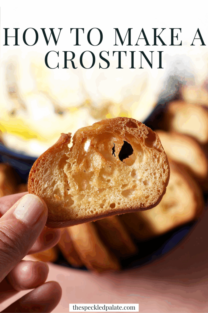 A hand holds a crostini above creamy dip and a platter with more crostini with the text how to make a crostini
