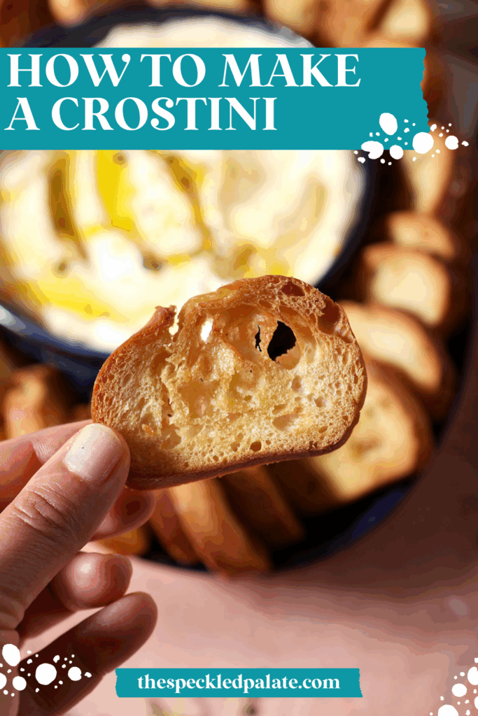 A hand holds a crostini above creamy dip and a platter with more crostini with the text how to make a crostini