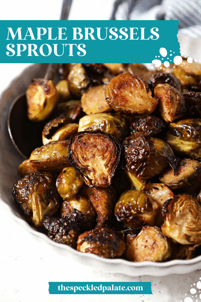A bowl of Roasted Brussels Sprouts on a white surface with a spoon in it with the text maple brussels sprouts