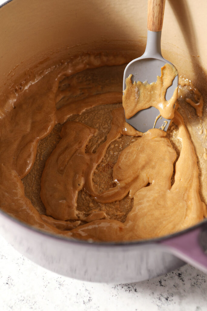 Caramel in a pot with a grey rubber spatula