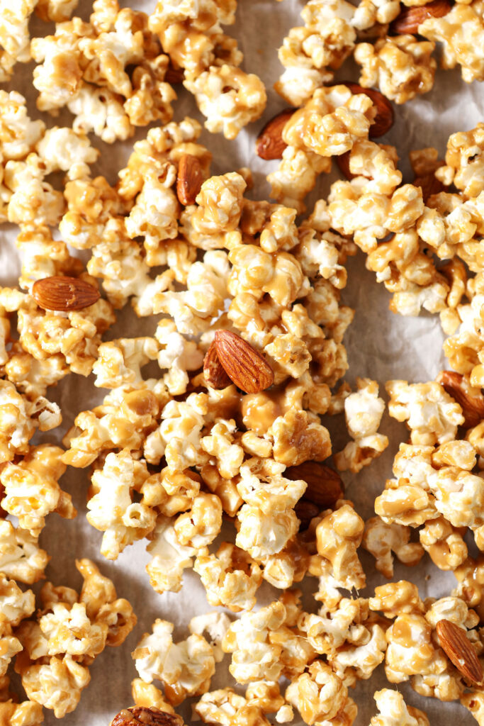 Caramel corn with almonds on a sheet pan before baking