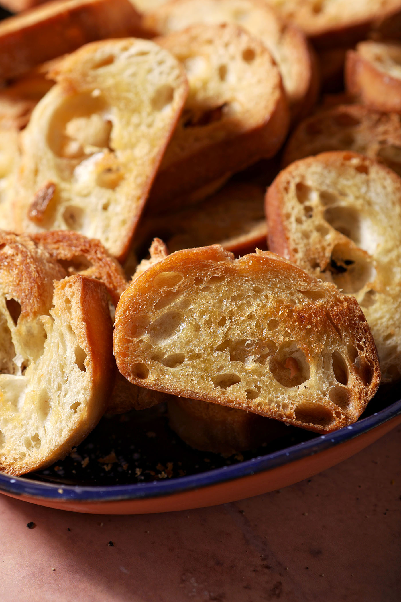 Crostini crackers stacked in a blue serving dish