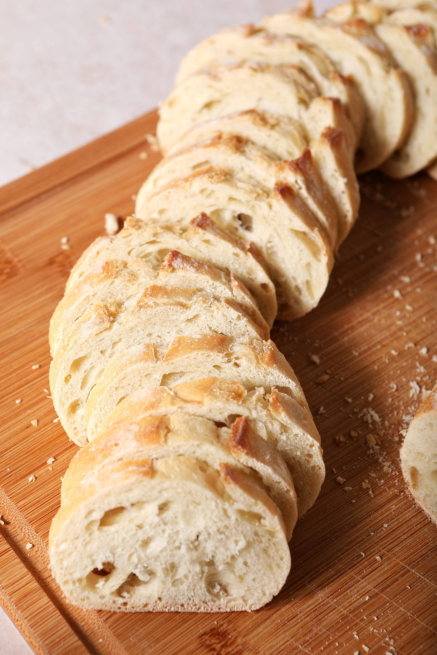 Sliced baguette rounds on a wooden cutting board