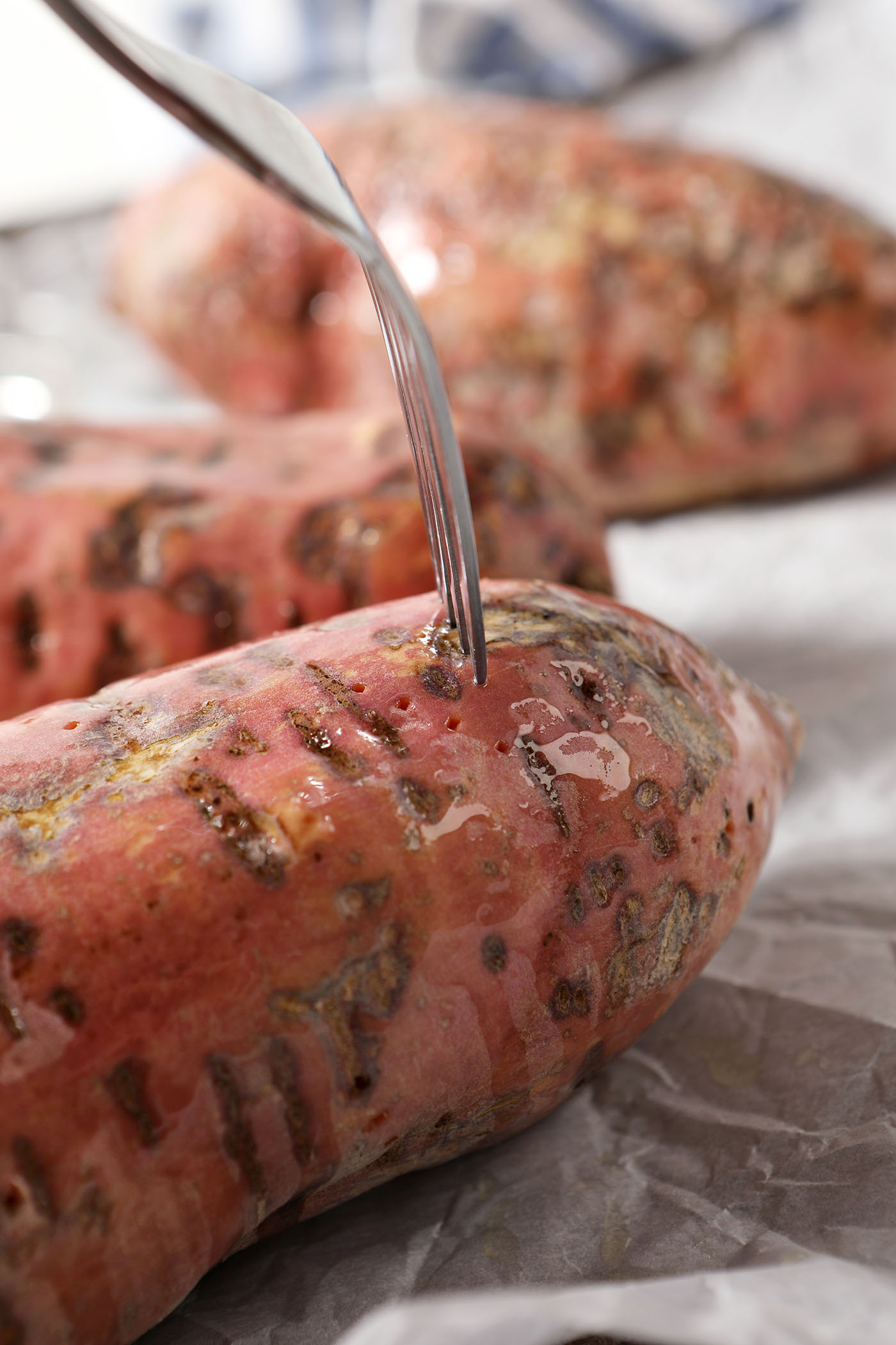 A fork spears an oiled sweet potato