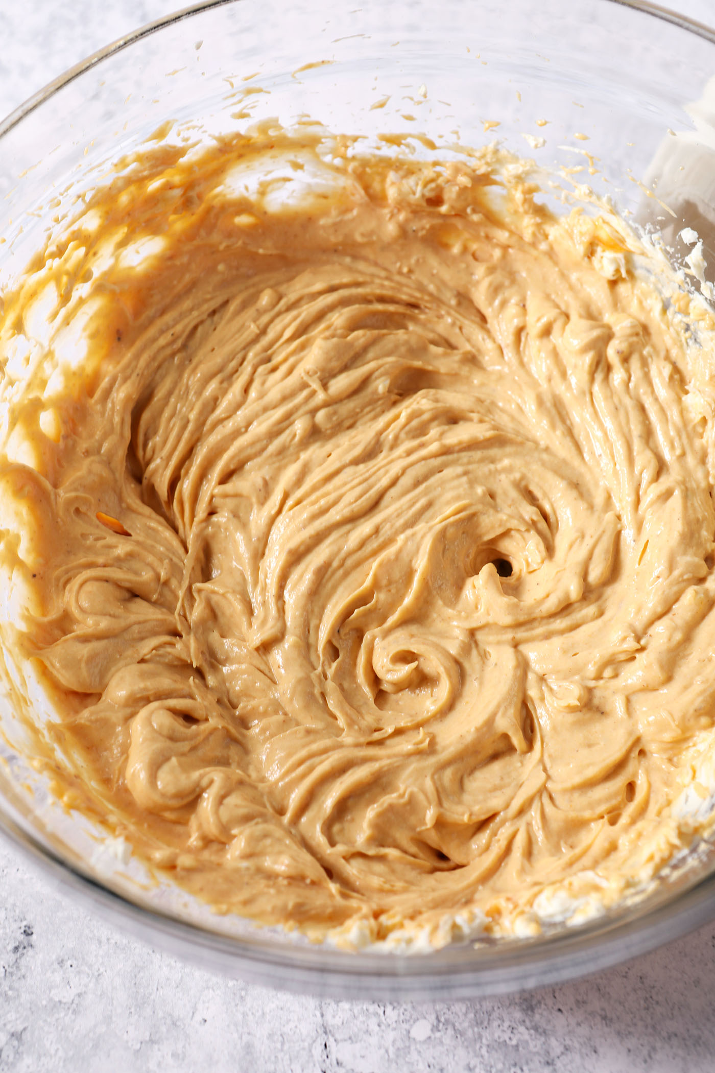 The beginning ingredients of cheesecake pumpkin dip whipped together in a large bowl