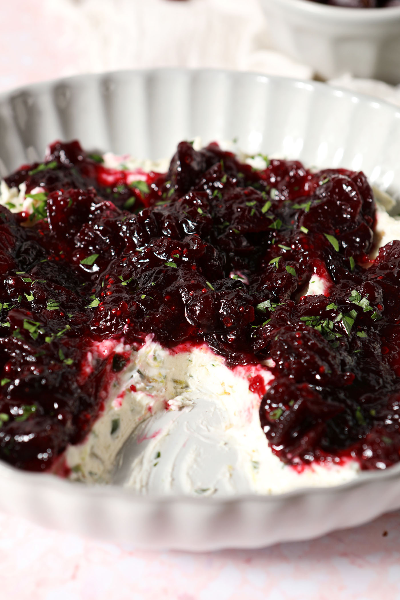Close up of the side of a bowl of a cranberry dip recipe with jalapeño cream cheese