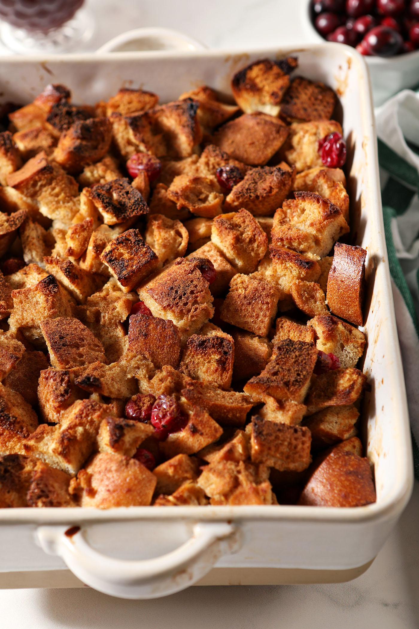 A casserole dish of cranberry French toast on a marble surface